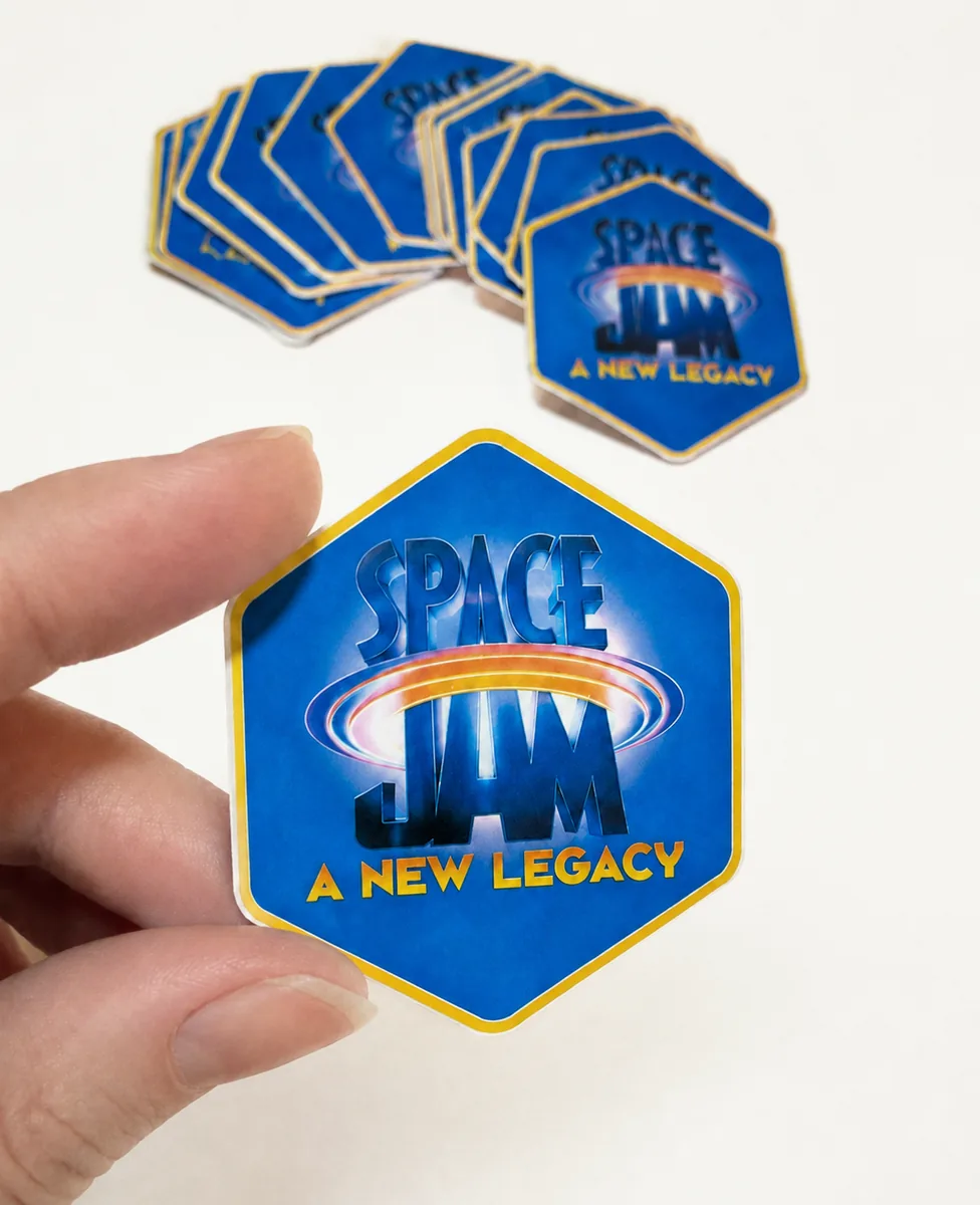 Stickers troquelados con el logo de una marca, sostenidos en la mano